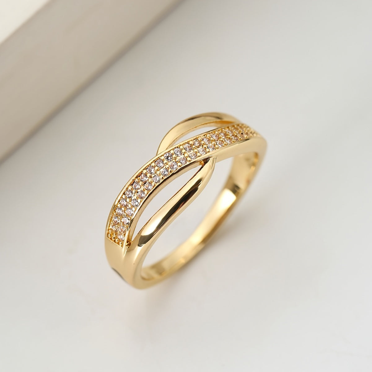 Eleganter goldfarbener Crossover-Ring mit Steinen